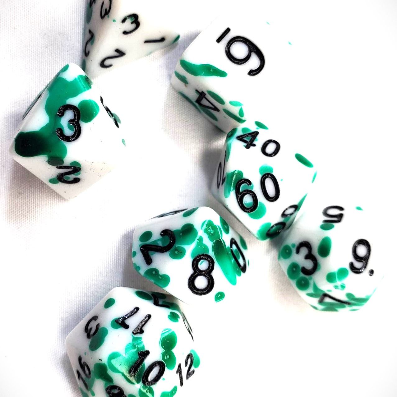 White Acrylic Dice Set with Green Splatter and Black Numbering
